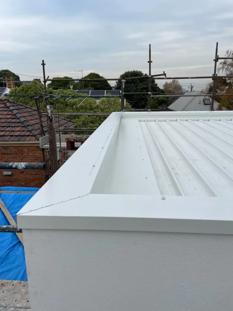 New profiled steel roof with box gutter and neatly finished capping on an extension